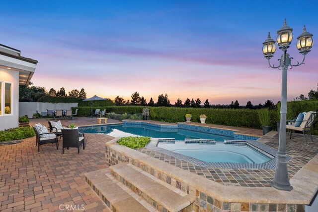 view of pool featuring a patio and a pool with connected hot tub