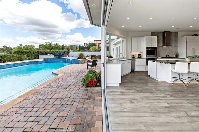 swimming pool with area for grilling and a patio area