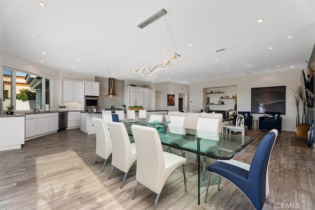 dining area with recessed lighting, light wood-style flooring, and a chandelier