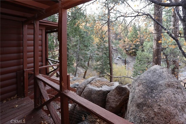 wooden terrace featuring a wooded view