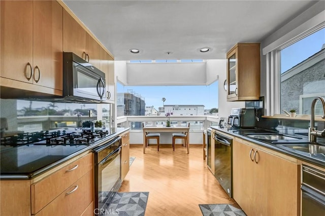 16745 Bayview Dr Unit B, Sunset Beach, CA 90742 - kitchen with oven, dishwasher, black microwave, light wood-style flooring, and dark countertops