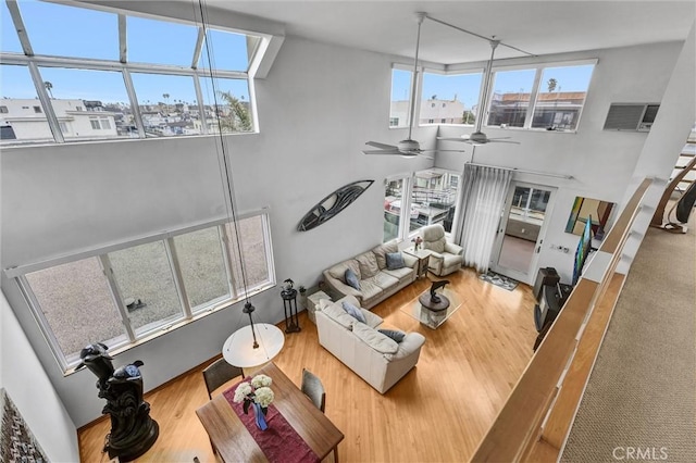 16745 Bayview Dr Unit B, Sunset Beach, CA 90742 - living area with wood finished floors, a ceiling fan, and a towering ceiling