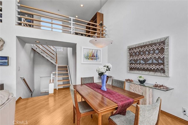 16745 Bayview Dr Unit B, Sunset Beach, CA 90742 - dining area with wood finished floors, a towering ceiling, recessed lighting, stairs, and baseboards