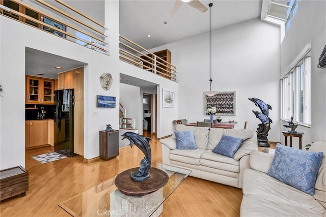 16745 Bayview Dr Unit B, Sunset Beach, CA 90742 - living room with a high ceiling, light wood-style flooring, ceiling fan, stairs, and recessed lighting