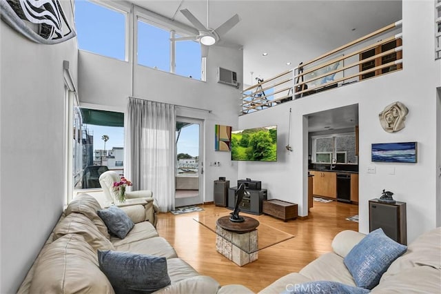 16745 Bayview Dr Unit B, Sunset Beach, CA 90742 - living room featuring ceiling fan, a towering ceiling, wood finished floors, and a wall unit AC