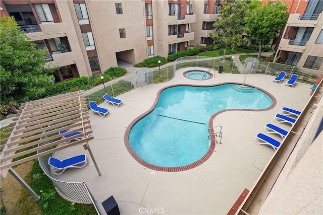 community pool featuring fence, a community hot tub, and a patio area