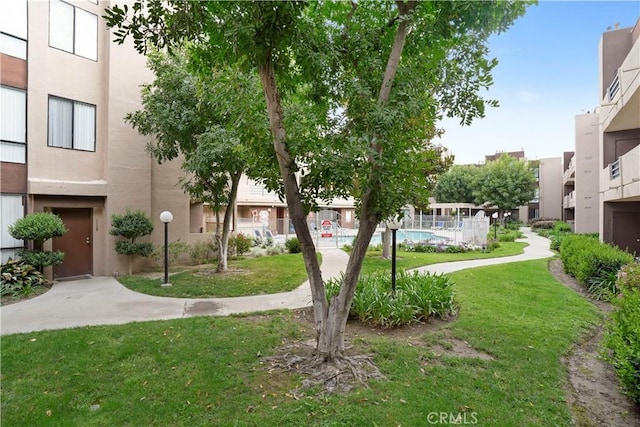 view of property's community with a lawn and a swimming pool