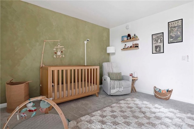 bedroom with a crib, baseboards, and carpet floors