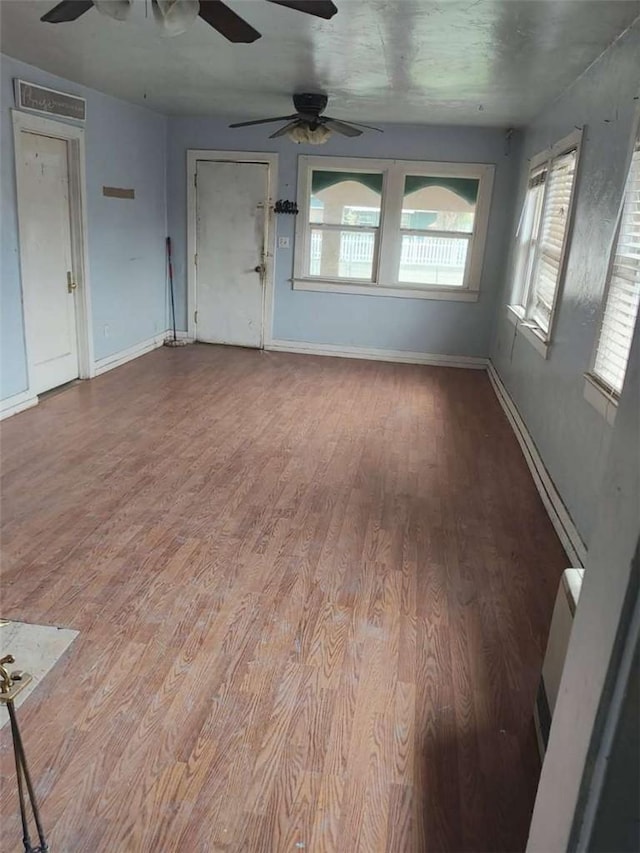 107 N Rine St, Alturas, CA 96101 - unfurnished living room featuring a ceiling fan, wood finished floors, plenty of natural light, and baseboards