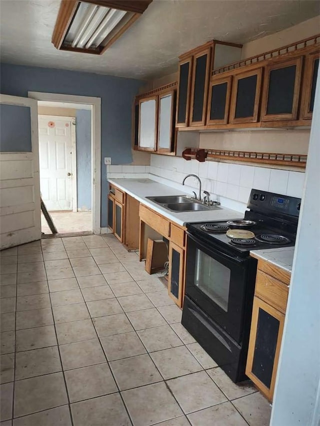 107 N Rine St, Alturas, CA 96101 - kitchen featuring black range with electric stovetop, a sink, light countertops, tasteful backsplash, and light tile patterned floors