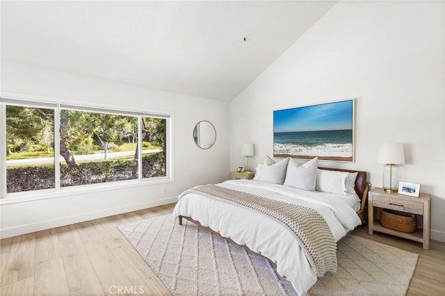 bedroom featuring baseboards, wood finished floors, and vaulted ceiling