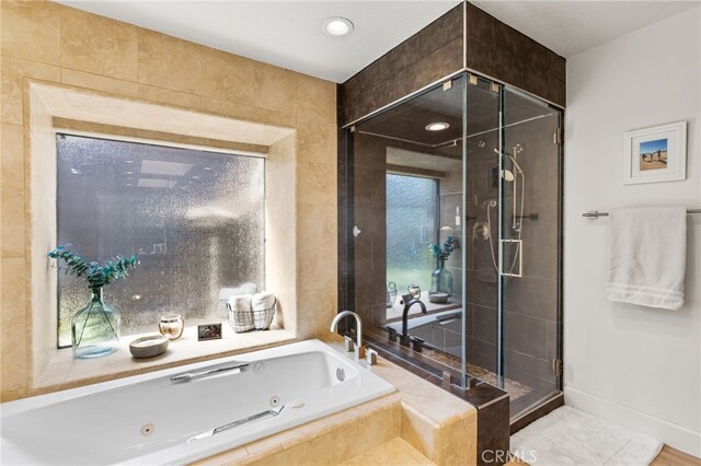 full bath with baseboards, a tub with jets, and a stall shower