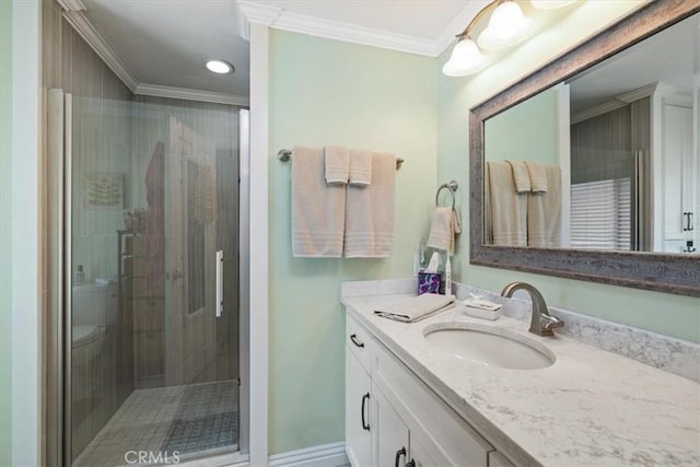 full bathroom featuring a stall shower, baseboards, crown molding, and vanity