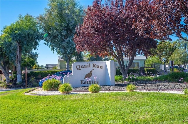 community sign featuring fence and a yard