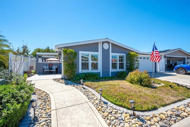 view of front of home with driveway, fence, and a garage