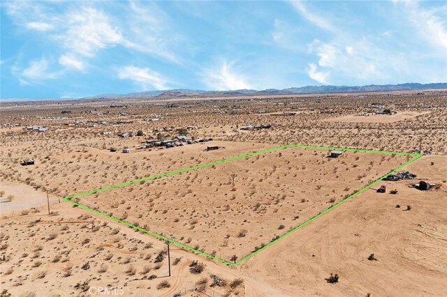 drone / aerial view with a mountain view, a rural view, and view of desert