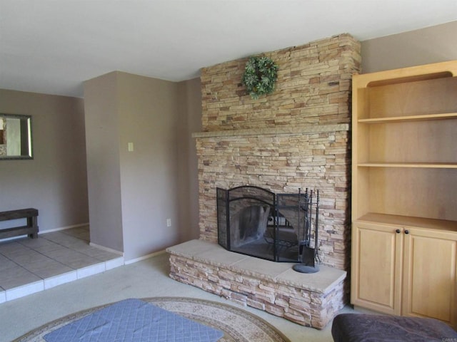 unfurnished living room featuring baseboards and a fireplace with raised hearth