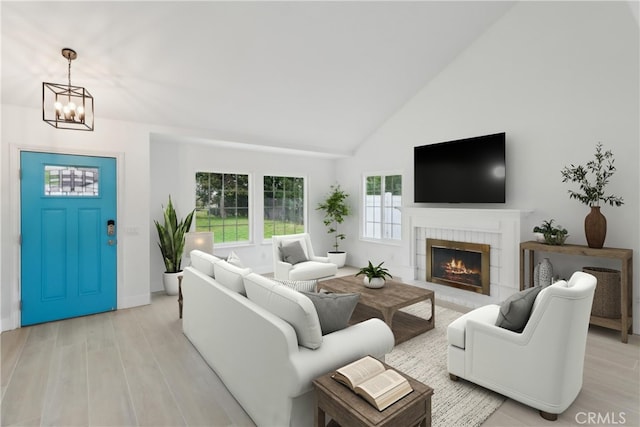 23010 Finch St, Grand Terrace, CA 92313 - living room featuring a chandelier, light wood-style floors, a lit fireplace, and high vaulted ceiling
