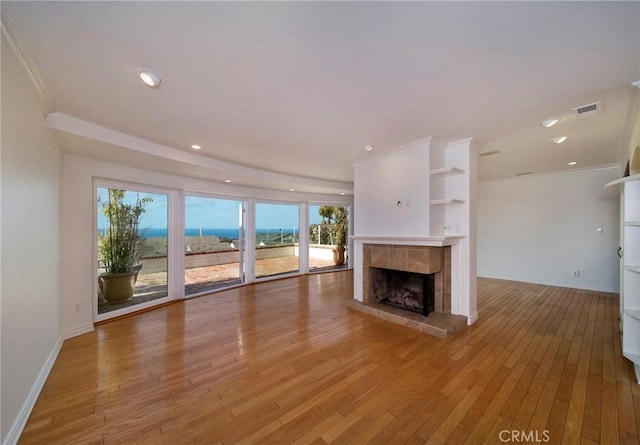 33571 Binnacle Dr, Dana Point, CA 92629 - unfurnished living room featuring a tiled fireplace, light wood-type flooring, healthy amount of natural light, baseboards, and ornamental molding