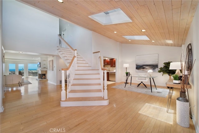 33571 Binnacle Dr, Dana Point, CA 92629 - stairs with a skylight, a lit fireplace, hardwood / wood-style flooring, wood ceiling, and high vaulted ceiling