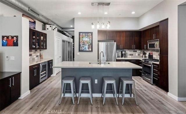 133 The Promenade N Unit 317, Long Beach, CA 90802 - kitchen featuring stainless steel appliances, a sink, wine cooler, backsplash, and a breakfast bar area