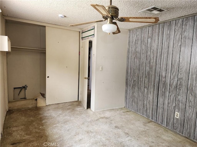 unfurnished bedroom featuring a textured ceiling, a closet, a ceiling fan, and visible vents