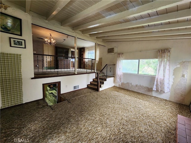carpeted spare room with stairs, a notable chandelier, beamed ceiling, and visible vents