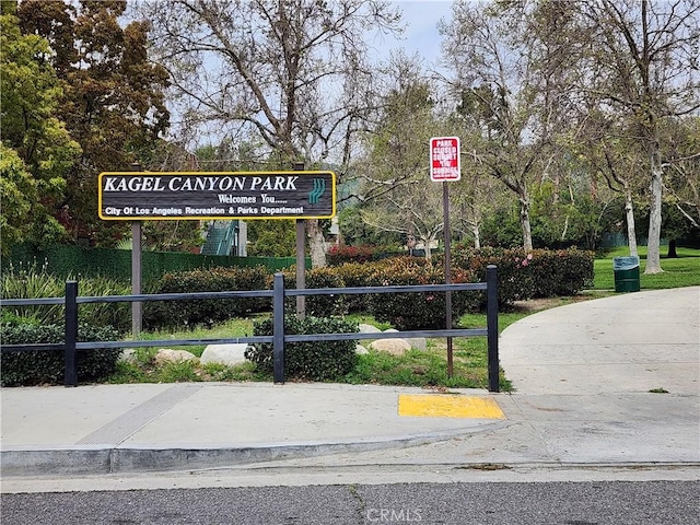 view of community featuring fence and uncovered parking