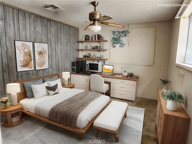 bedroom with visible vents, built in desk, a ceiling fan, wood walls, and light colored carpet