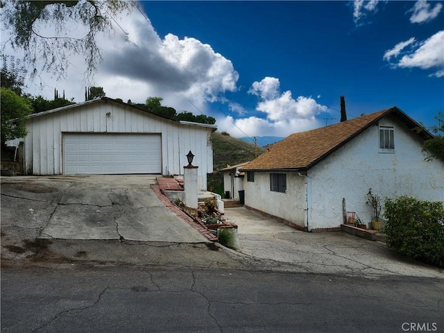 view of front of home featuring an outbuilding, a garage, and stucco siding