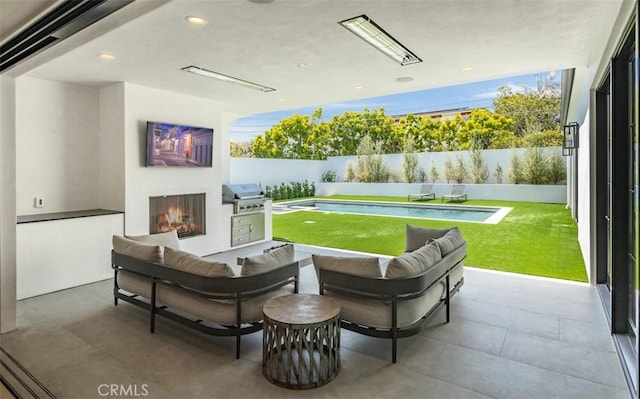 interior space with grilling area, an outdoor living space with a fireplace, a fenced in pool, and a fenced backyard