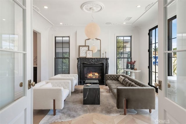 living area with a high end fireplace, visible vents, and recessed lighting