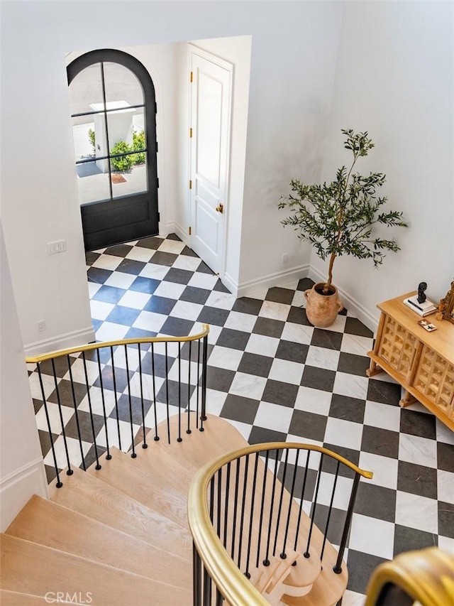 foyer entrance featuring stairway, baseboards, and tile patterned floors