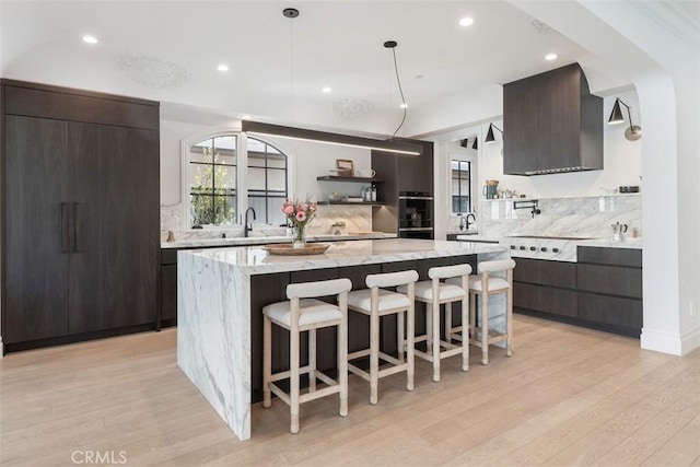 kitchen featuring modern cabinets, tasteful backsplash, and a kitchen breakfast bar