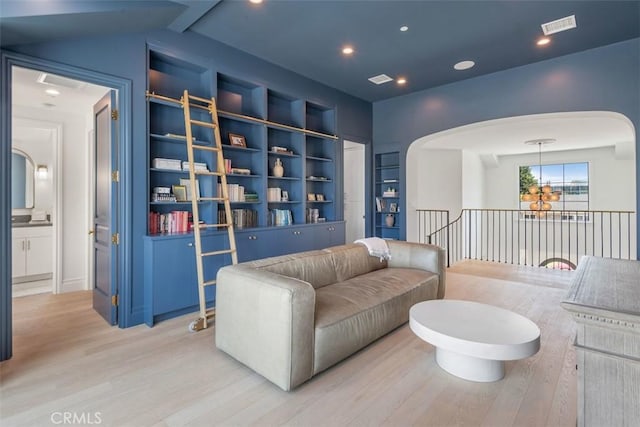 living room with visible vents, arched walkways, wood finished floors, and recessed lighting