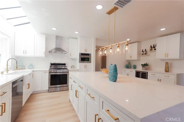 26306 Ganiza, Mission Viejo, CA 92692 - kitchen with stainless steel appliances, wall chimney exhaust hood, a sink, wine cooler, and a center island