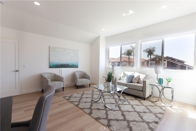 living room with baseboards, recessed lighting, and light wood finished floors