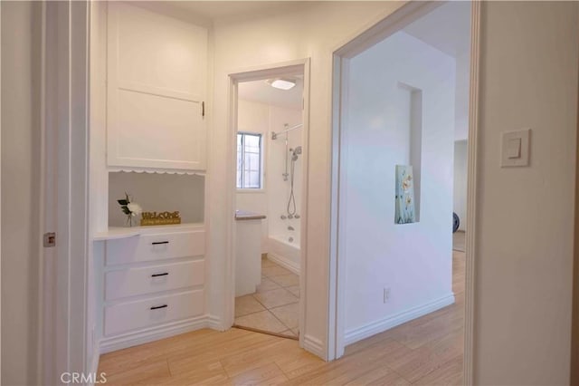 full bathroom with baseboards, wood finished floors, and shower / washtub combination