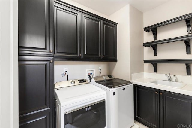 clothes washing area with cabinet space, washer and clothes dryer, and a sink