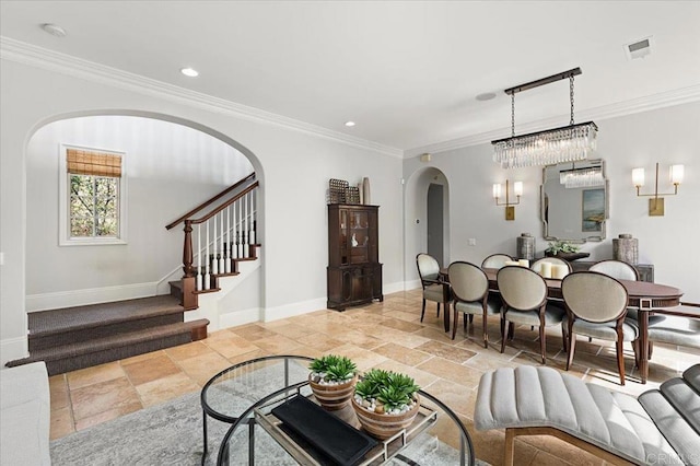 living area with arched walkways, ornamental molding, and stone tile flooring