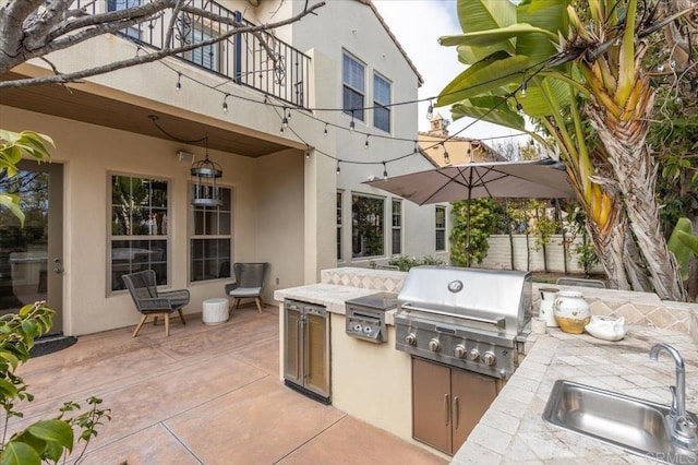view of patio / terrace with area for grilling, grilling area, a sink, fence, and a balcony