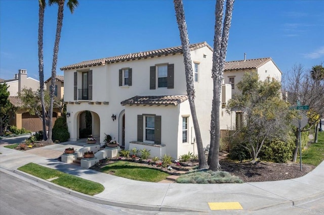 mediterranean / spanish-style house with stucco siding and a tiled roof