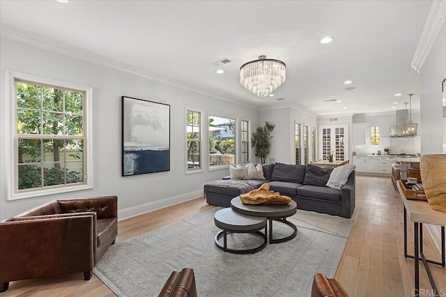 living area featuring light wood-type flooring, an inviting chandelier, plenty of natural light, and recessed lighting