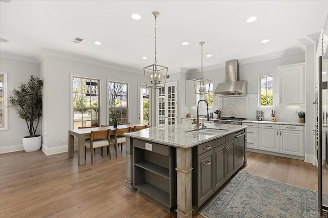 kitchen with a sink, open shelves, white cabinetry, and wall chimney exhaust hood