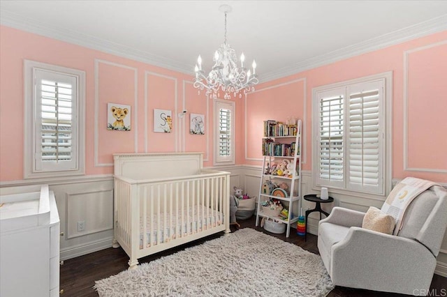 bedroom with a decorative wall, an inviting chandelier, and dark wood finished floors