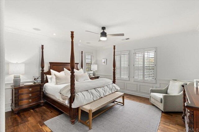 bedroom with visible vents, ornamental molding, a ceiling fan, wood finished floors, and a wainscoted wall