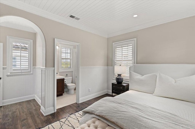 bedroom featuring crown molding, visible vents, a wainscoted wall, and dark wood-style floors