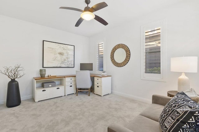 office featuring light carpet, baseboards, and ceiling fan