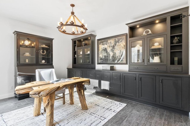 interior space with baseboards, a notable chandelier, and dark wood finished floors