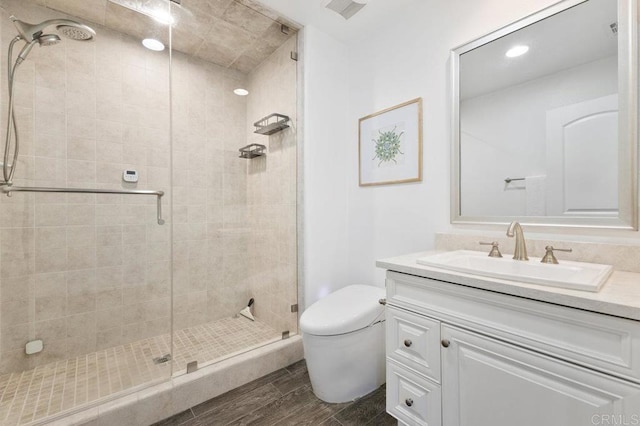 full bath with toilet, wood finished floors, visible vents, and a stall shower
